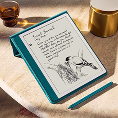 An open e-book on a green Amazon Kindle e-reader alongside other things on a wooden table.